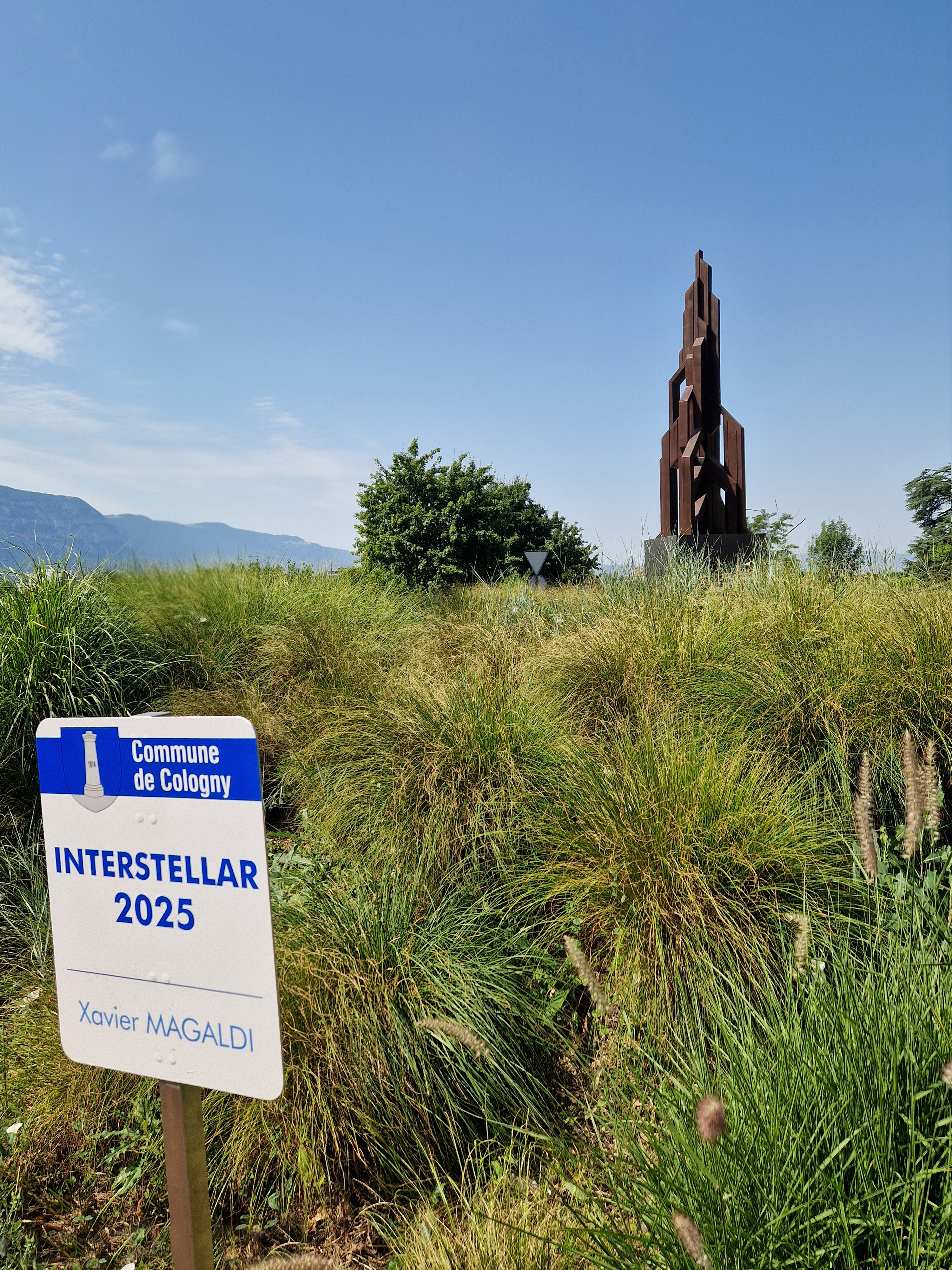Vue de l'oeuvre Interstellar de Xavier Magaldi sur le giratoire de la route de Vandoeuvres, panneau au premier plan