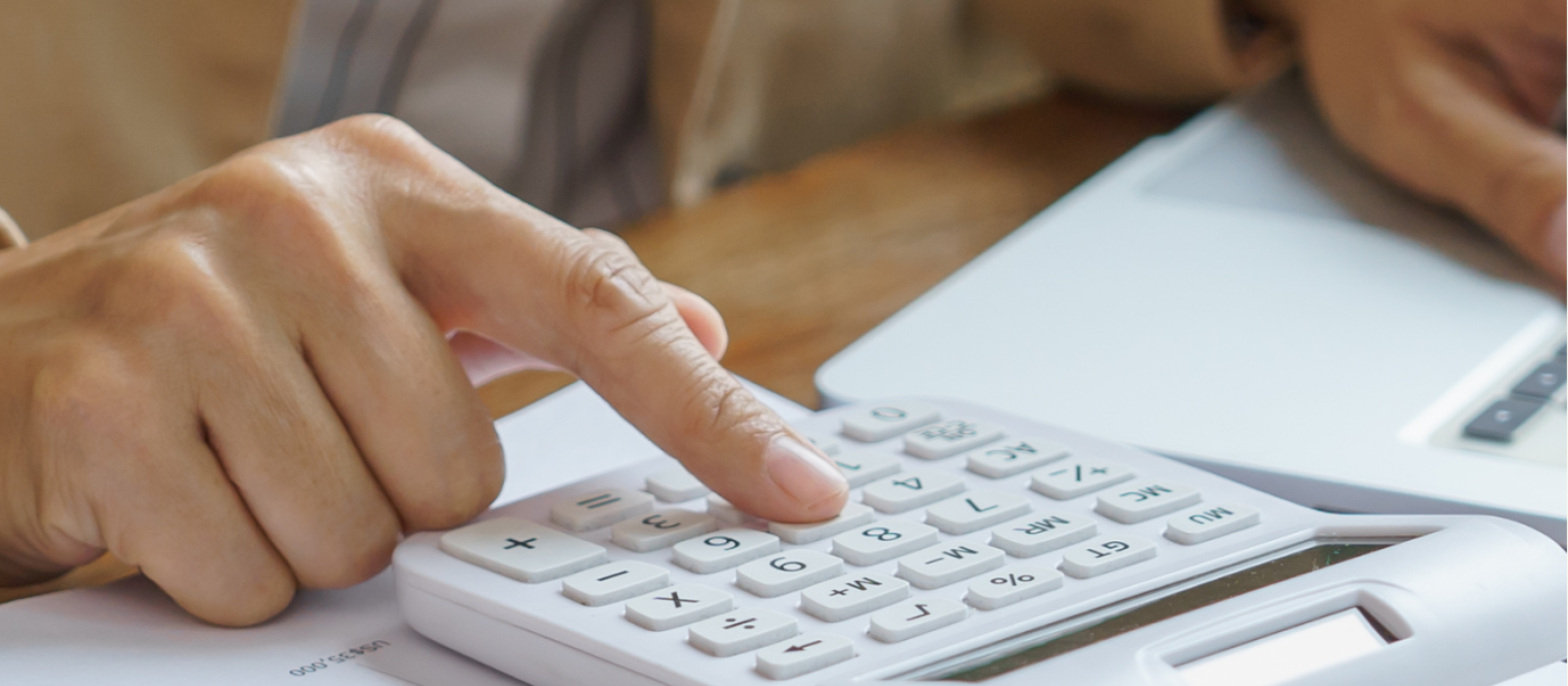 illustration: vue d'une table avec des documents, une calculatrice et la main d'une personne